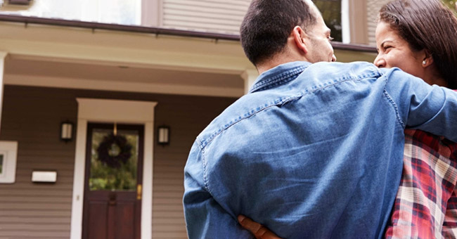 Couple in front of their new home